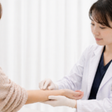 医師が患者の腕を触診している様子
