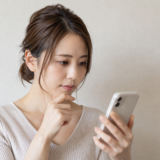 スマートフォンで調べものをする女性