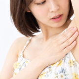 自分の脇に触れている女性