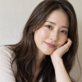肘をついて微笑む女性