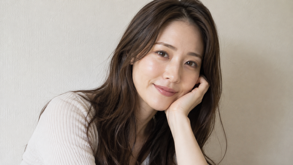 肘をついて微笑む女性