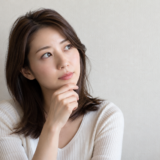 顎に手を当てて考える女性